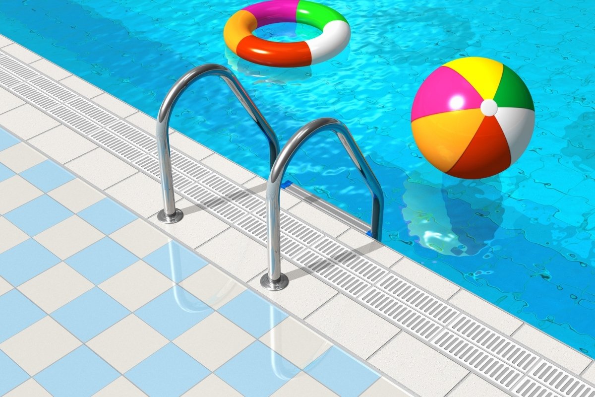 Medence színes úszógumival és strandlabdával, csempézett burkolattal