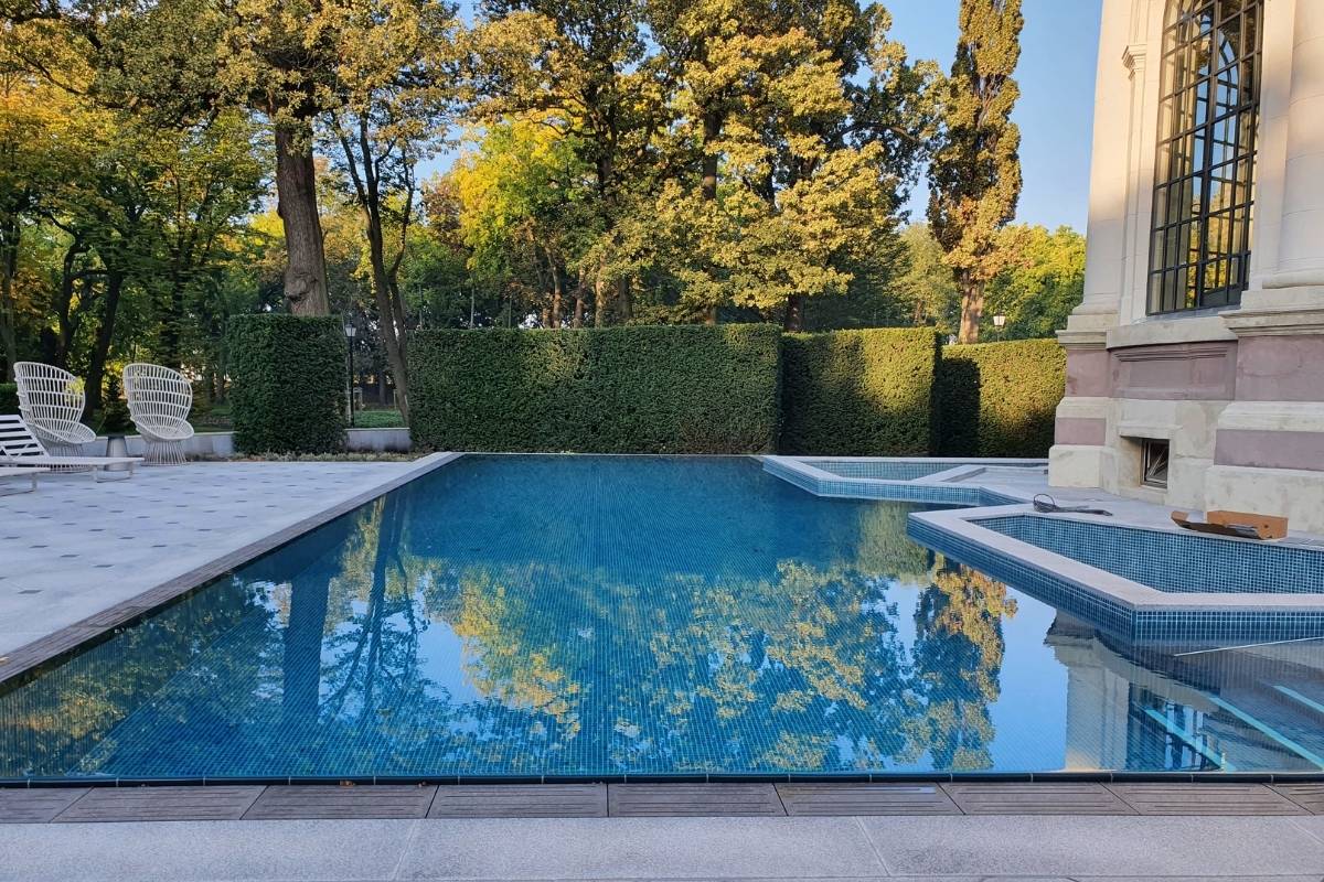 Luxus kültéri medence mozaikburkolattal, elegáns villa kertjében