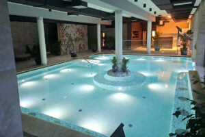 Luxus hotel beltéri wellness medencéje mozaikburkolattal, elegáns világítással és prémium kivitelezéssel.