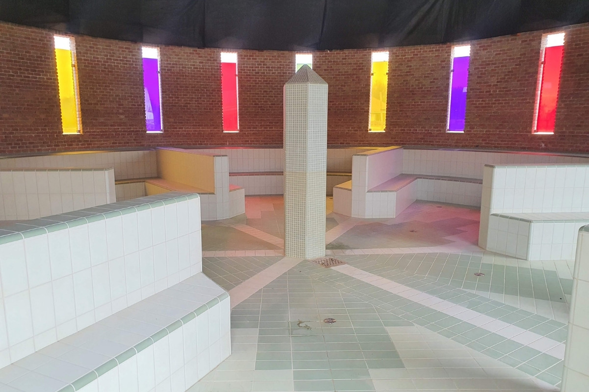 Kör alakú medencetér felújított csempeburkolattal és színes üvegablakokkal a Zorál Medence kivitelezésében.