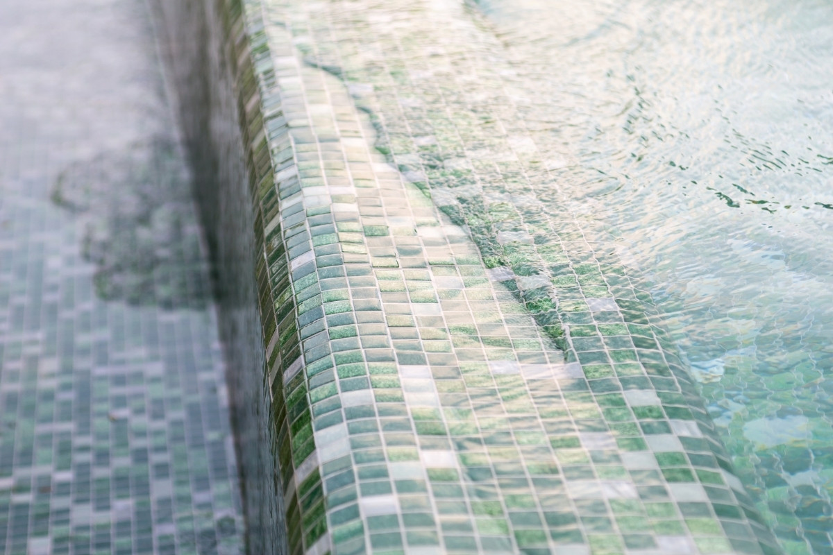 Mozaikburkolattal kialakított medenceperem víz alatt, tartós epoxi fugázással